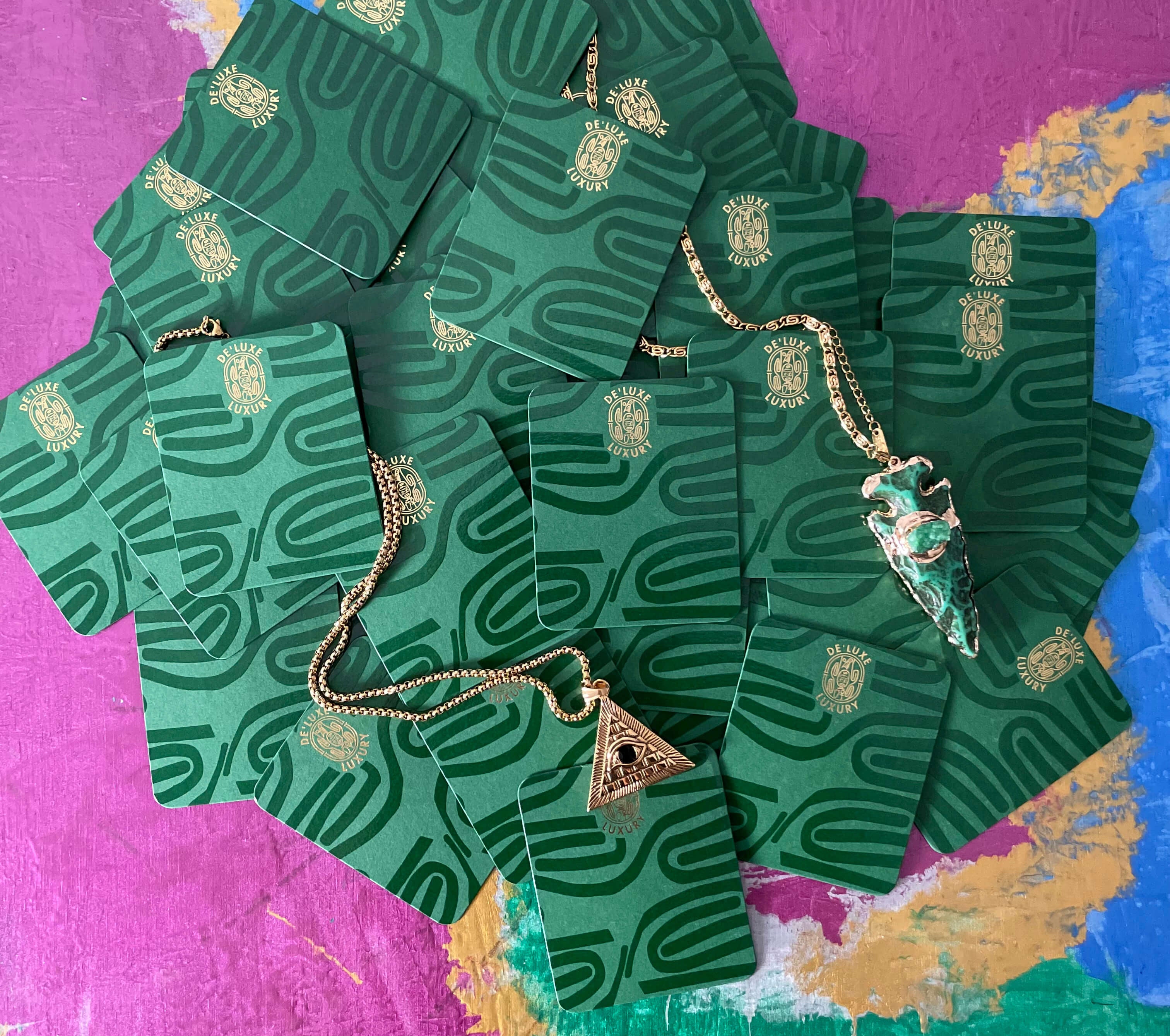 Translation missing: en.De'Luxe Luxury philosophy cards on a table intertwined with 2 gold chains