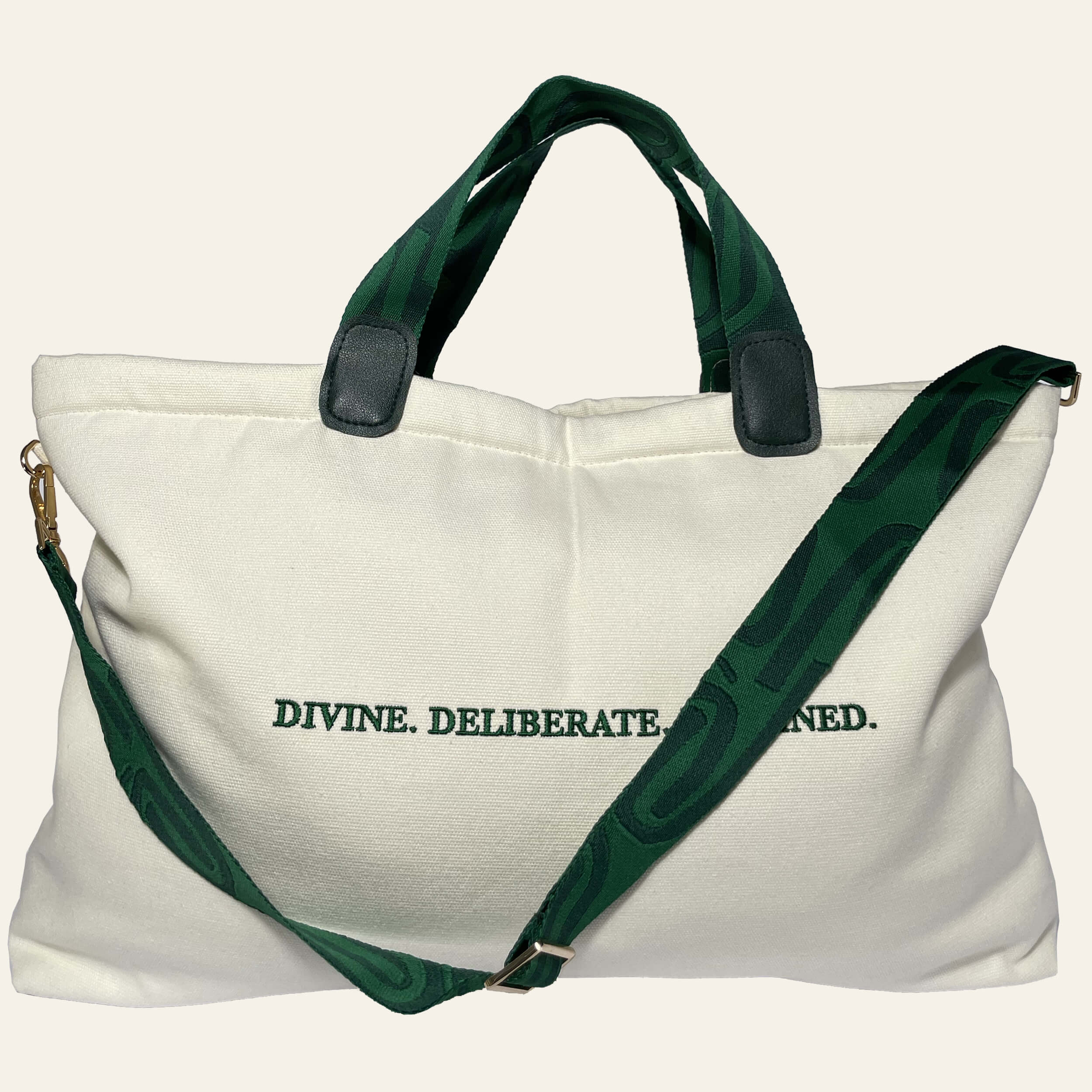 De'Luxe Luxury Voyage Tote back view with emerald Divine.Deliberate. Destined embroidery. Bag is made of 100% cotton canvas, color is cream, jacquard knit handles and adjustable with scarab path pattern in emerald and deep emerald.