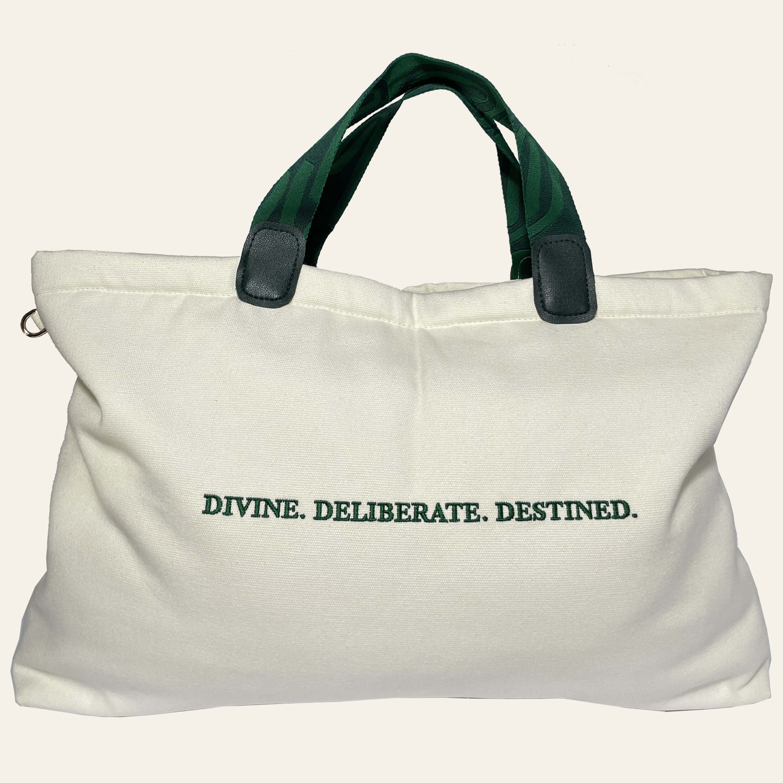 De'Luxe Luxury Voyage Tote back view with emerald Divine.Deliberate. Destined embroidery. Bag is made of 100% cotton canvas, color is cream, jacquard knit handles with scarab path pattern in emerald and deep emerald.